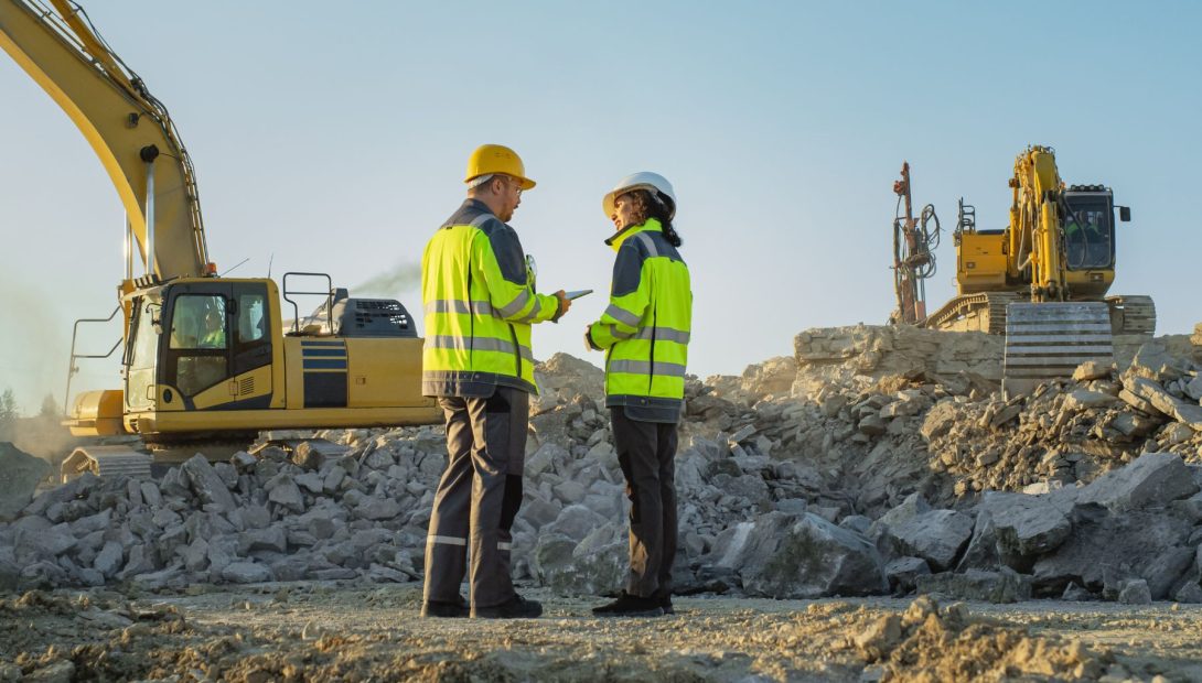 Civil engineering site with workers and excavators clearing rubble